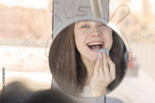 Beautiful woman in front of the mirror make up herself photo