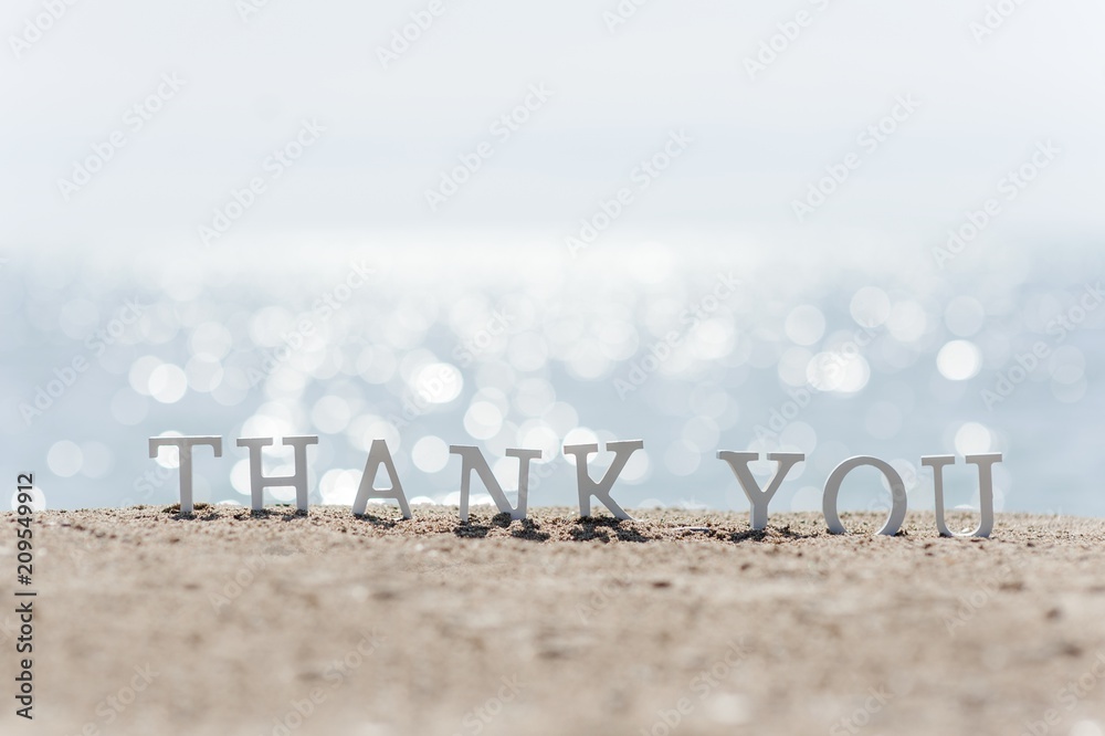 thank you word drawn on the beach sand