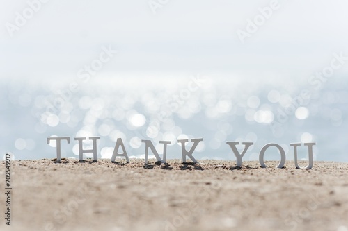 thank you word drawn on the beach sand