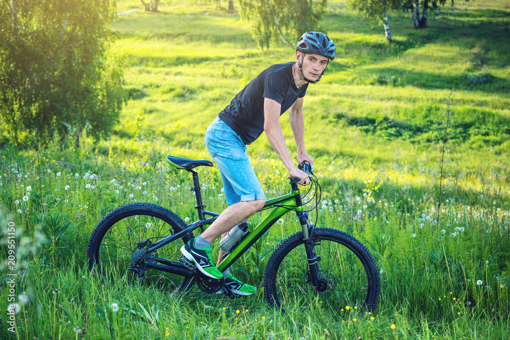 Man in a helmet riding on a mountain bike in the woods. Cyclist in motion. Active and healthy lifestyle