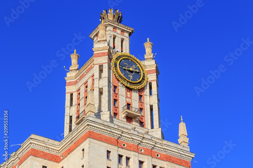 Tower with thermometer of Lomonosov Moscow State University (MSU) against blue sky in sunny summer evening photo