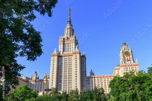 Lomonosov Moscow State University (MSU) in sunny summer evening on a green trees background