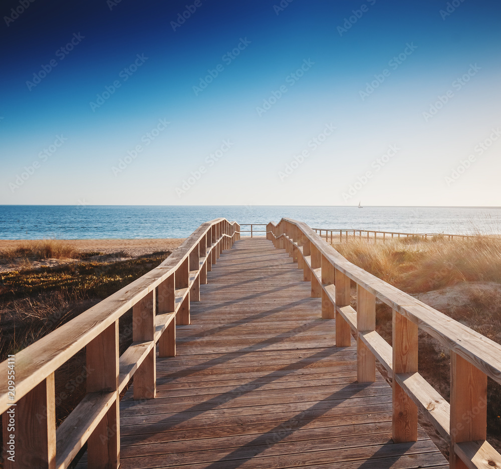 Fototapeta premium drewniana ścieżka do morza o zachodzie słońca, piękny krajobraz, Algarve, Portugalia