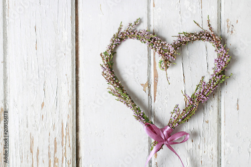 Foto Heather (erica) door wreath in heart shape on wooden background