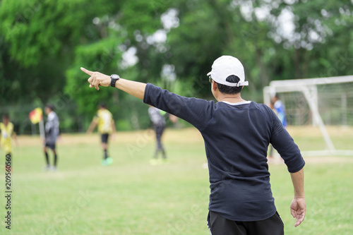 Football or socker coach observing kid football match.Healthy sport concept.