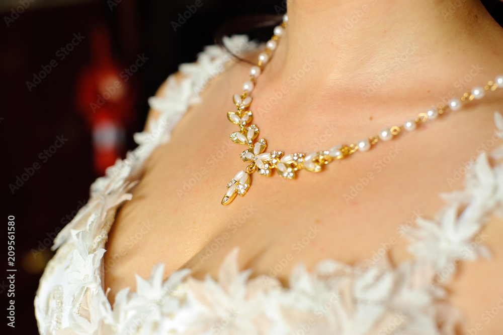 Necklace on the woman's neck.