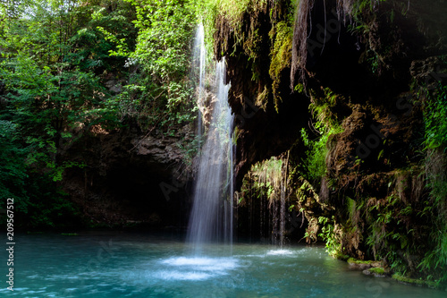 Waterfall and a beautiful lagoon lake for relaxing in the summer forest.