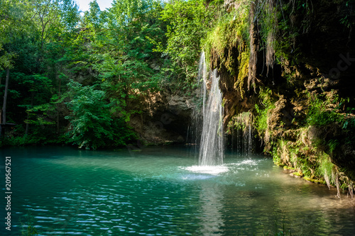 Fototapeta Naklejka Na Ścianę i Meble -  Waterfall and a beautiful lagoon lake for relaxing in the summer forest.