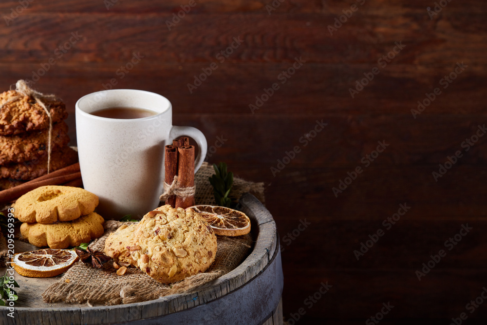 White porcelain mug of tea and sweet cookies on wooden background, top view, selective focus White porcelain mug of tea and sweet cookies on wooden background, top view, selective focus