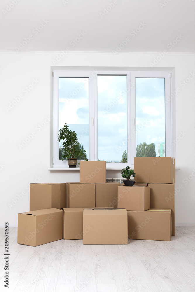 Moving into a new apartment. Move lots of cardboard boxes in an empty new apartment. Moving into a new apartment. Move lots of cardboard boxes in an empty new apartment.