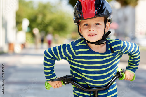 Kid with bike and helmet smiles