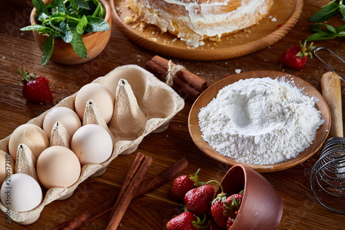 Top view raw ingredients for cooking strawberry pie or cake on wooden table, flat lay. Bakery background. photo