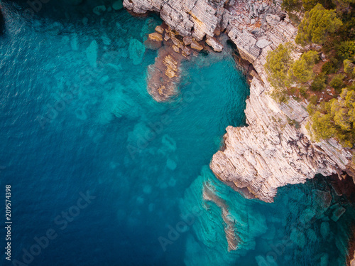 top view of the rocky shore of the crystal clear Adriatic Sea, drone shot