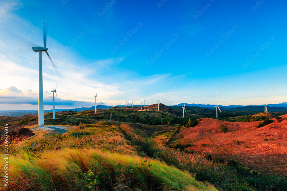 The Pililla Windmills harnessing clean energy during a golden sunset. It is a 54MW wind farm overlooking Laguna de Bay in Sitio Bugarin, Pililla Rizal, Philippines.