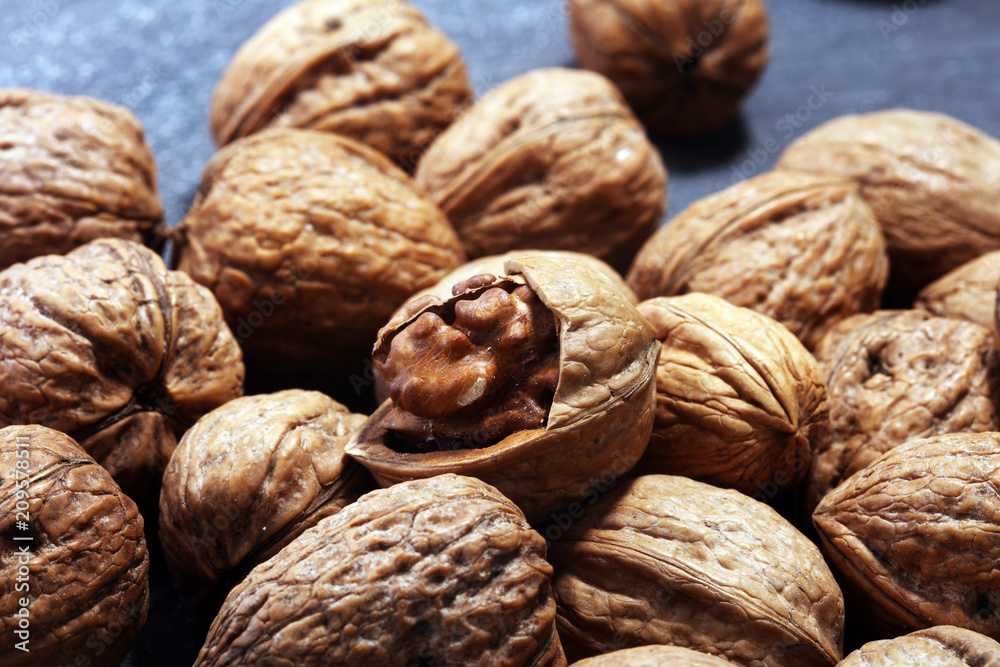 Walnut kernels and whole walnuts on rustic old table Walnut kernels and whole walnuts on rustic old table