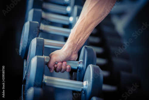 Strong bodybuilder man lifting weights in the sport gym, close up ,bodybuilding and muscle building concept. © May_Chanikran