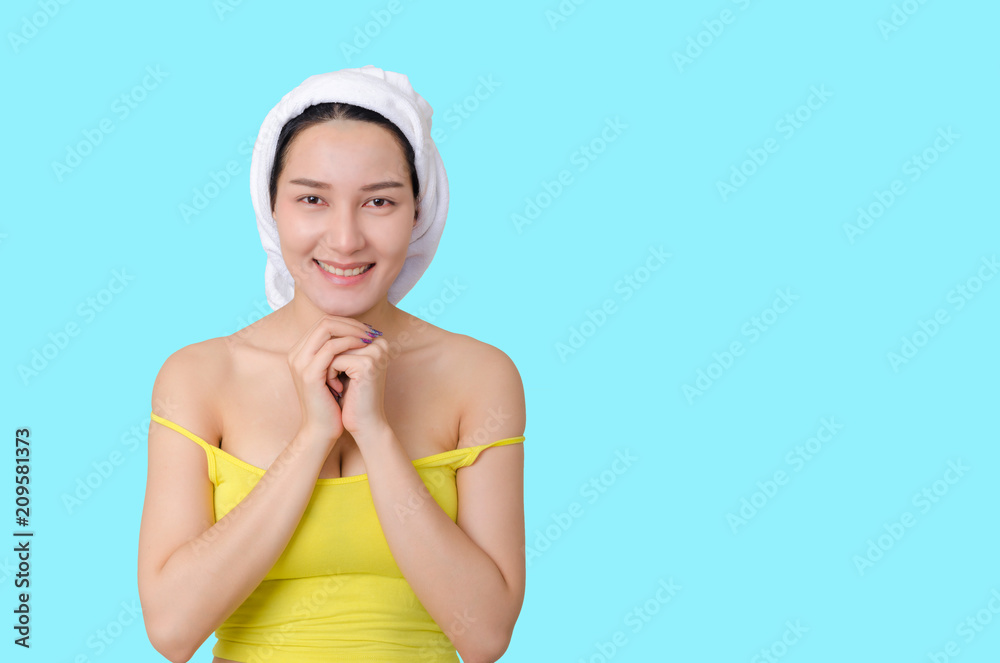 portrait of beautiful girl face retouching skin care and spa concept with towel cover on hair and smile sexy or cute pose isolated on blue background with clipping path. skin retouch beauty concept. portrait of beautiful girl face retouching skin care and spa concept with towel cover on hair and smile sexy or cute pose isolated on blue background with clipping path. skin retouch beauty concept.