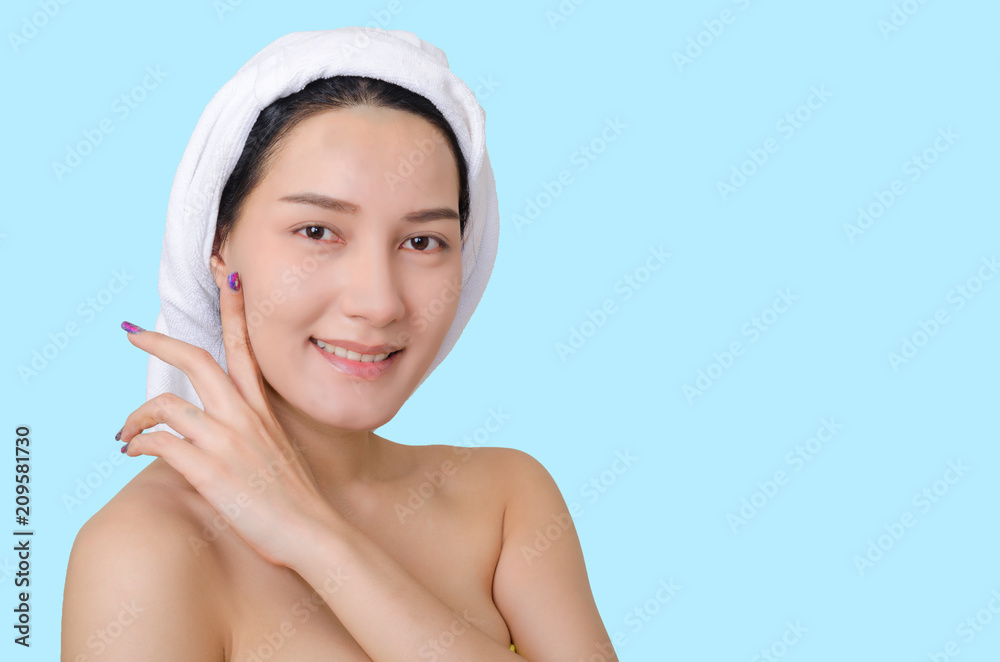 portrait of beautiful girl face retouching skin care and spa concept with towel cover on hair and smile sexy or cute pose isolated on blue background with clipping path. skin retouch beauty concept.