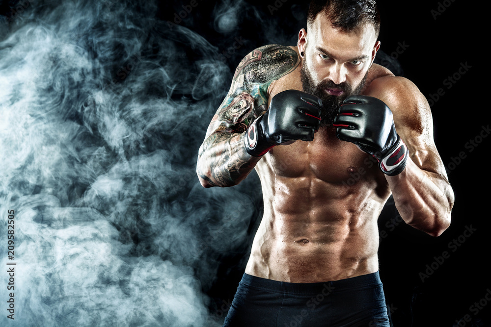Sportsman boxer fighting on black background with smoke. Copy Space. Boxing sport concept.