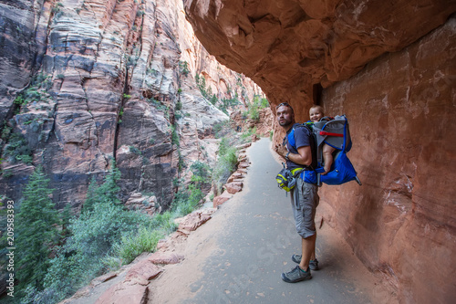 A man with his baby boy are trekking in Zion national park, Utah, USA