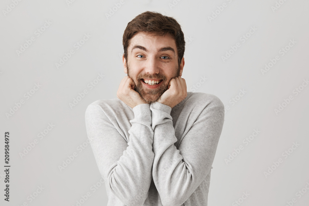 Guy can not control his emotions, wanting to hug lovely puppy. Portrait of excited european male model glancing at camera with hands near jaw and smile, seeing something awesome and cute Guy can not control his emotions, wanting to hug lovely puppy. Portrait of excited european male model glancing at camera with hands near jaw and smile, seeing something awesome and cute