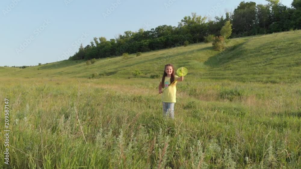 little girl is catching butterflies with a net in the grass little girl is catching butterflies with a net in the grass