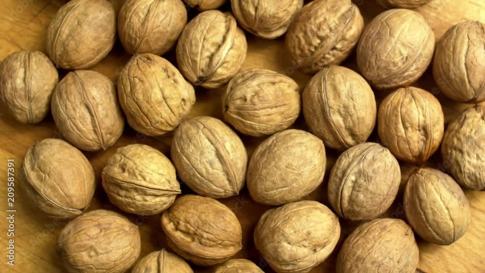 Walnuts on the wood desk. Rotating, turntable shot. Top view