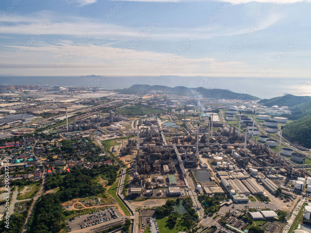 Obraz premium Industrial view at oil refinery plant form industry zone with sunrise and cloudy sky.Oil refinery and Petrochemical plant at dusk,Thailand. Aerial view
