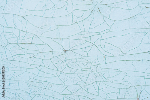 Textured background cracked blue paint on a wooden surface