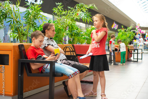 Mom with children on the bench in the mall photo