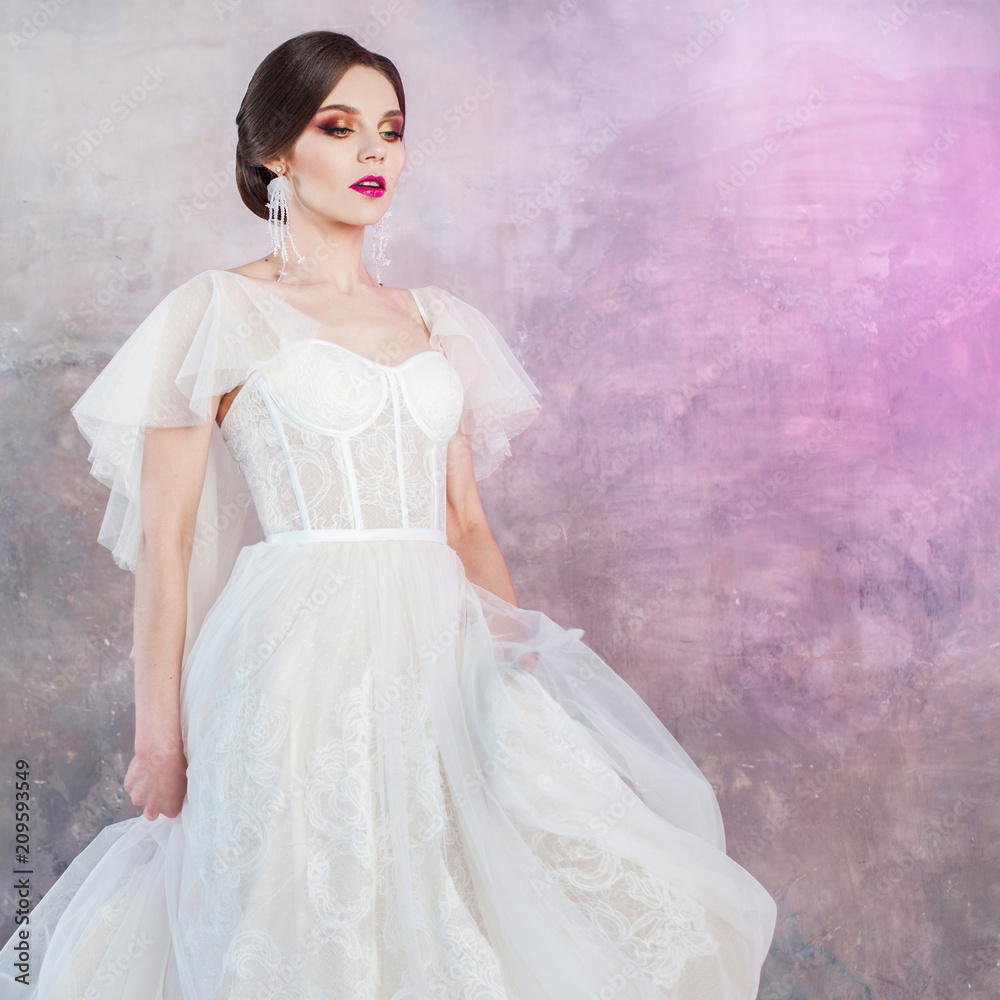 Beautiful and stylish bride in wedding dress in Studio on grey textured background Beautiful and stylish bride in wedding dress in Studio on grey textured background