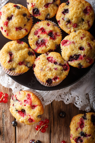 berry muffin with black and red currant close-up. Vertical top view from above