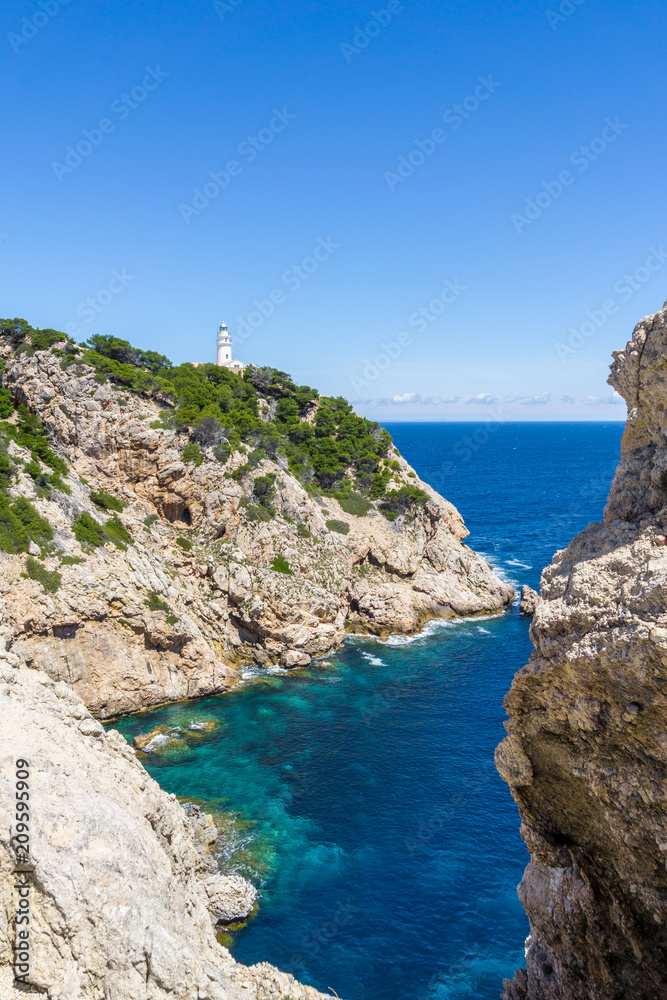 Mallorca, Blue clear sea water in bay between rocks and lighthouse of capdepera