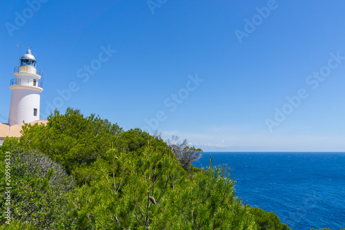 Mallorca, Ancient lighthouse of capdepera behind green plants