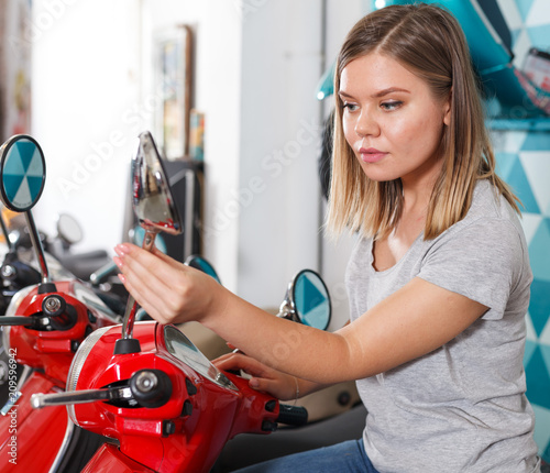 Woman is shopping and choosing new motobike