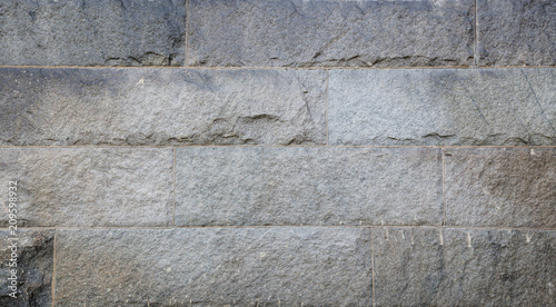 Full frame background of a wall made of big and rough stone blocks with vignette