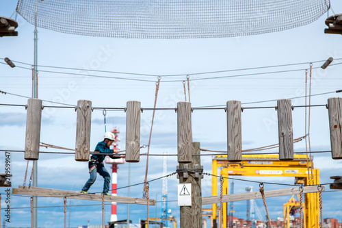 Brave little kid overcome track with obstacles in adventure park © Dmitrii