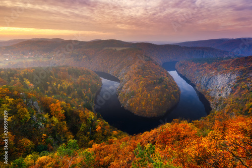 Panoramic view of river canyon with dark water and autumn colorful forest. Horseshoe bend, Vltava river, Czech republic. Beautiful landscape with river. Maj lookout.