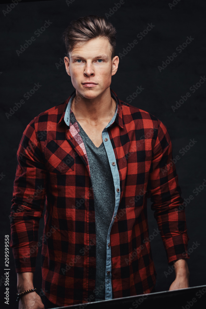 Close-up portrait of a handsome young man in a fleece shirt, posing at a studio.