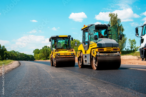 Obraz na płótnie industrial landscape with rollers that rolls a new asphalt in the roadway. Repair, complicated transport movement. w salonie