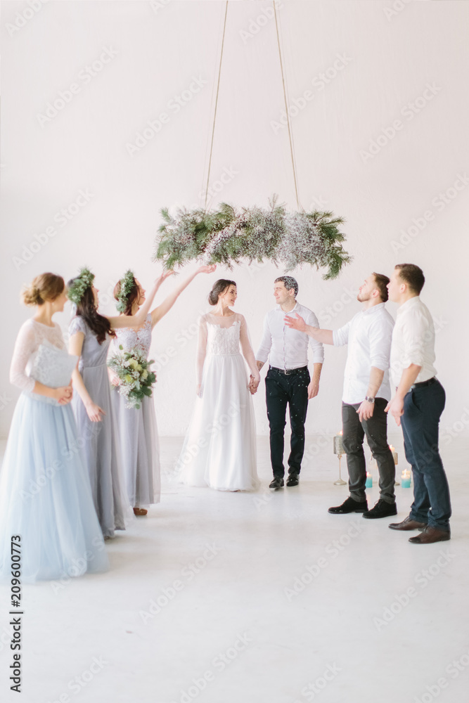 Bridesmaids and groommen throw rice on newlyweds groom and bride. Bridesmaids and groommen throw rice on newlyweds groom and bride.