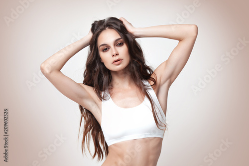 Sexy young woman in underwear on beige background