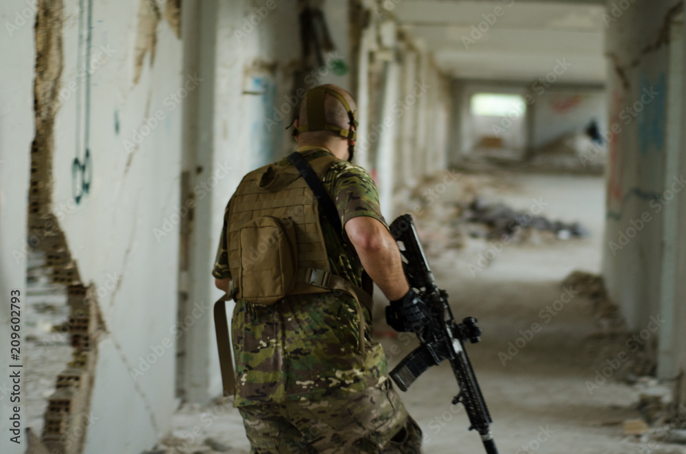 Soldier walking inside building hold down rifle Soldier walking inside building hold down rifle
