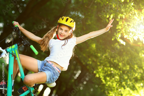 Girl riding a bike in the summer.