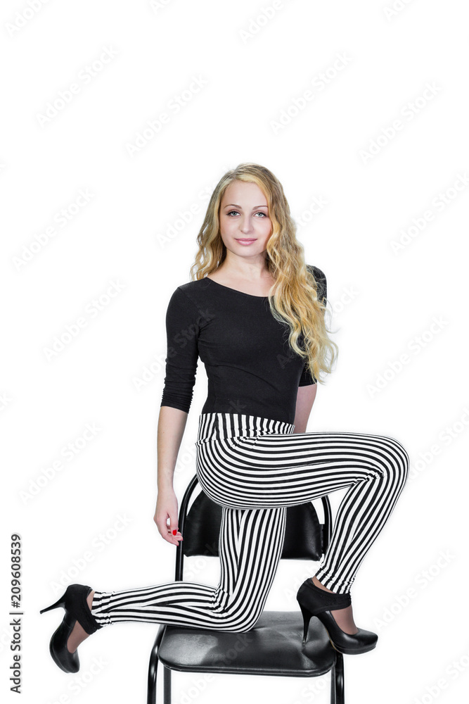 Fototapeta premium Beautiful blonde posing on chair. White background. Vertical photo.
