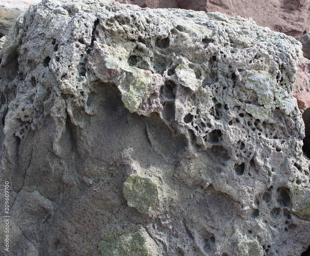 A natural stone of beautiful structure with cracks and interspersions close-up. A natural stone of beautiful structure with cracks and interspersions close-up.