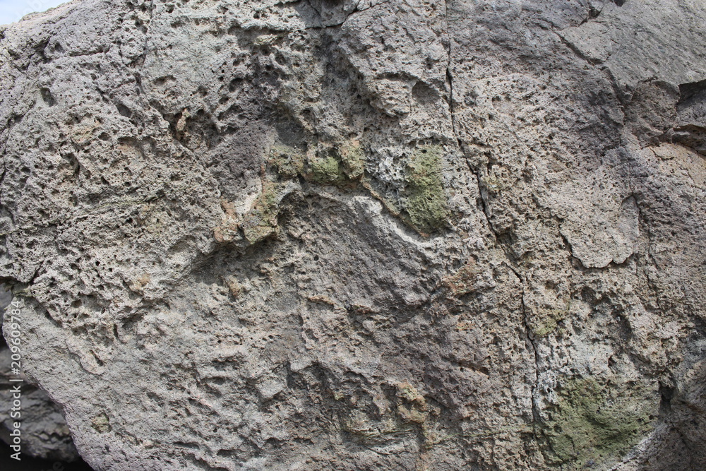A natural stone of beautiful structure with cracks and interspersions close-up. A natural stone of beautiful structure with cracks and interspersions close-up.