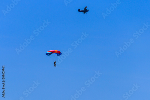 Parachutist and airplane in the blue sky. Active lifestyle. Extreme sport