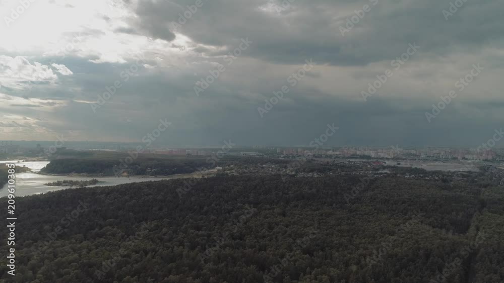 Flight over the forest. In the distance, on the horizon, you can see a large city Flight over the forest. In the distance, on the horizon, you can see a large city