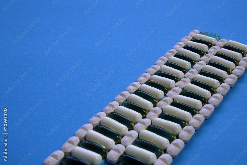 Naklejka premium tablets and capsules on a blue background